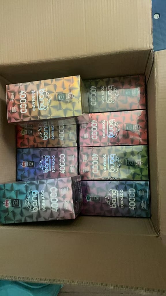 Een kartonnen doos gevuld met verschillende kleurrijke vape-producten met het label &quot;Bang Tornado 4000.&quot;